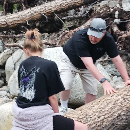 Randy helping Adaira cross a fallen log over Woodbine Creek.